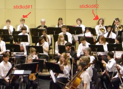 The boys sit in the back row, the trumpeter on the left, the trombone on the right