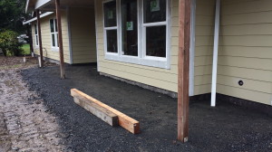 Front porch:  The paved portion will extend a couple feet beyond the overhang.  It will give us a little more flexibility with traffic patterns and keep cars from accidentally hitting the uprights!  Not sure what those short beams are for...