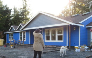 The hat of one of the painters is on the right...  the sun starting to go down behind the trees, the gray gables over the blue house.  LOVE how it looks!