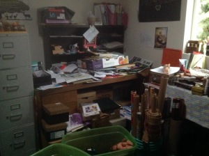 The desk is three feet deep and five feet wide.  The surface in this picture is covered in months of additions waiting for their homes.  Some of them belong on the shelves that are about to be mounted above, others will go in files in the cabinet to the left.  The small set of drawers and the sewing machine under the window have already been moved out, increasing the floor space by over 8 square feet!