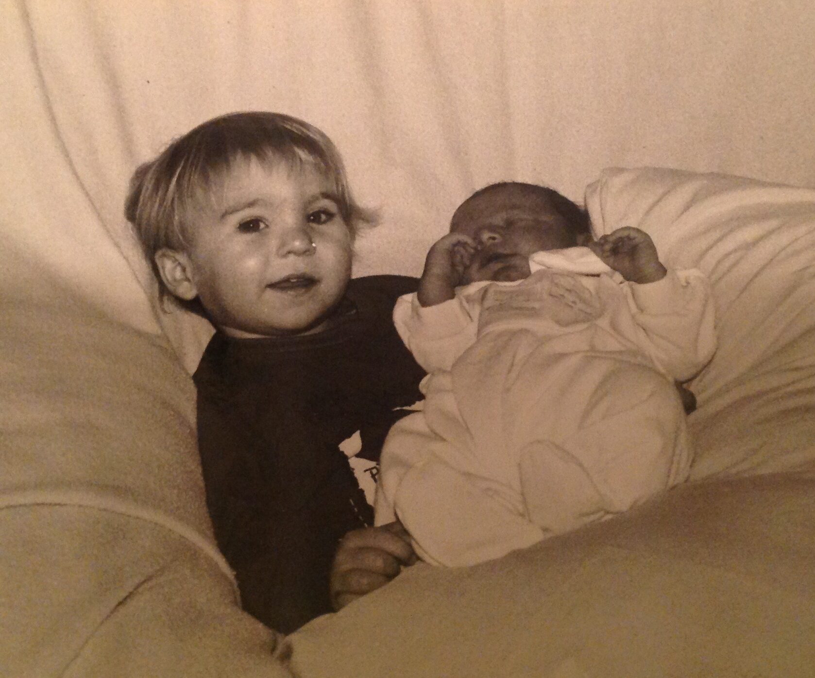 2-year old holding newborn